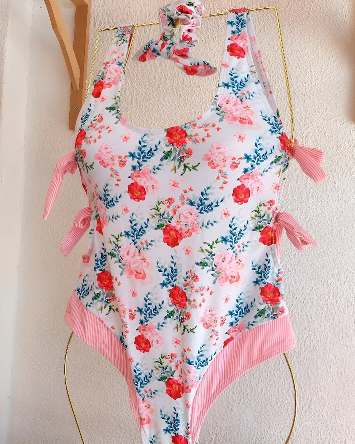Fato de banho de uma peça floral com folhos rosa e laços nas alças
