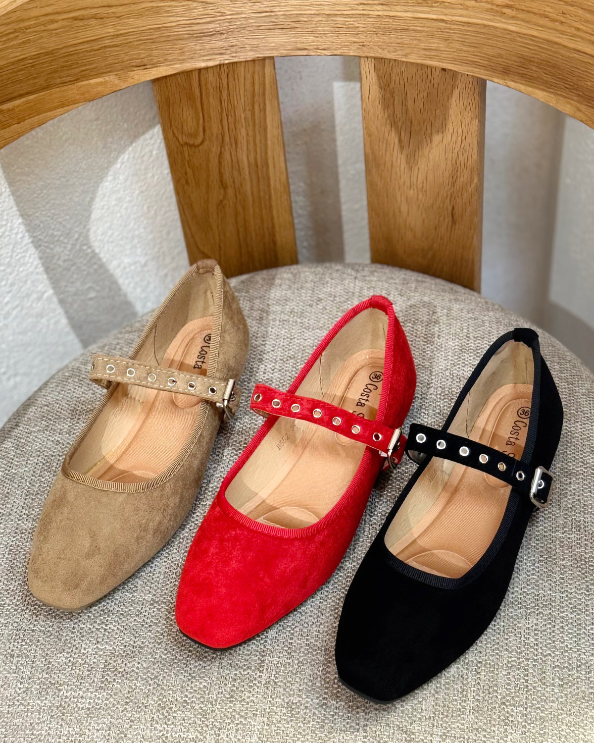 Sapatos em camurça bege, vermelhos e pretos, com tira e fivela metálica