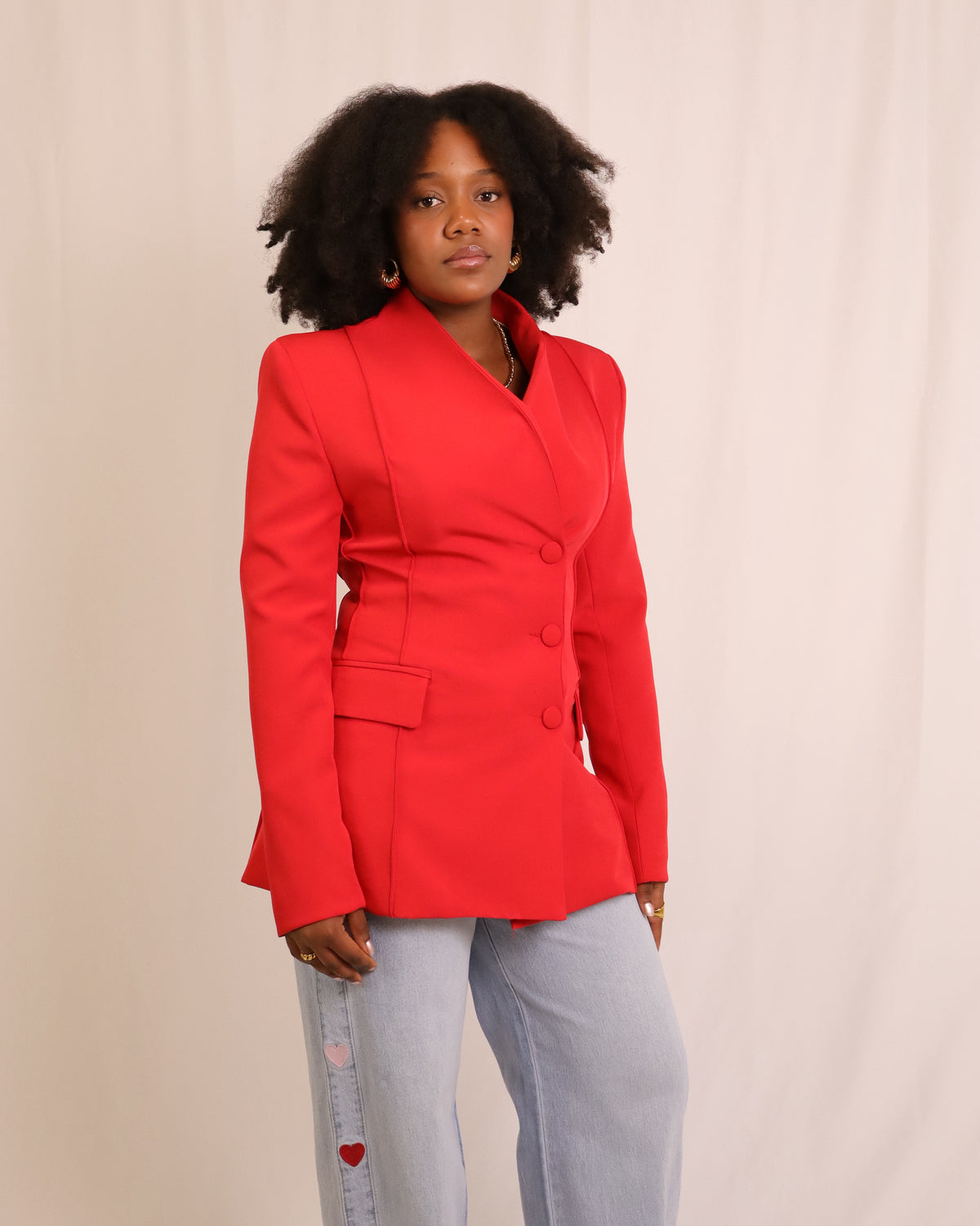 Blazer vermelho com botões frontais e dois bolsos com pala, vista lateral