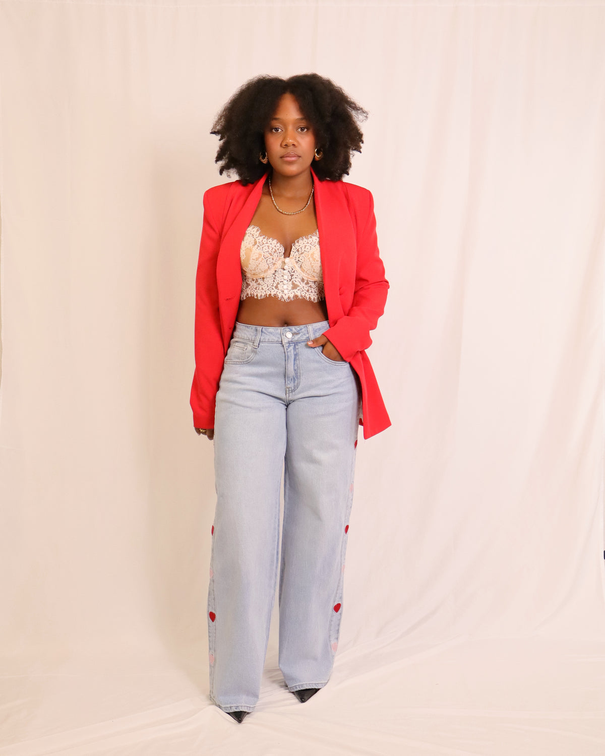 Blazer vermelho com lapelas em bico, botões e bolsos frontais, vista lateral