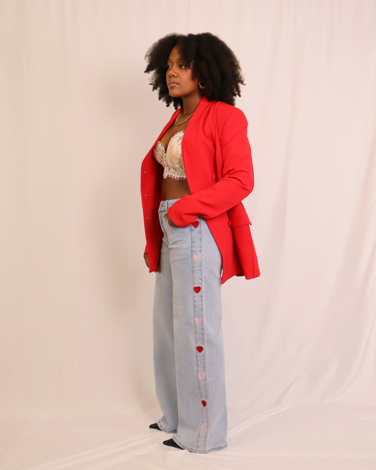 Blazer vermelho de corte estruturado, lapelas em bico e botões à frente, bolsos frontais