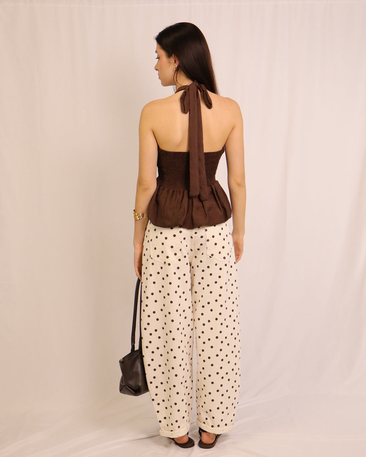 Calça balloon creme com bolinhas pretas, visão traseira e cintura elástica