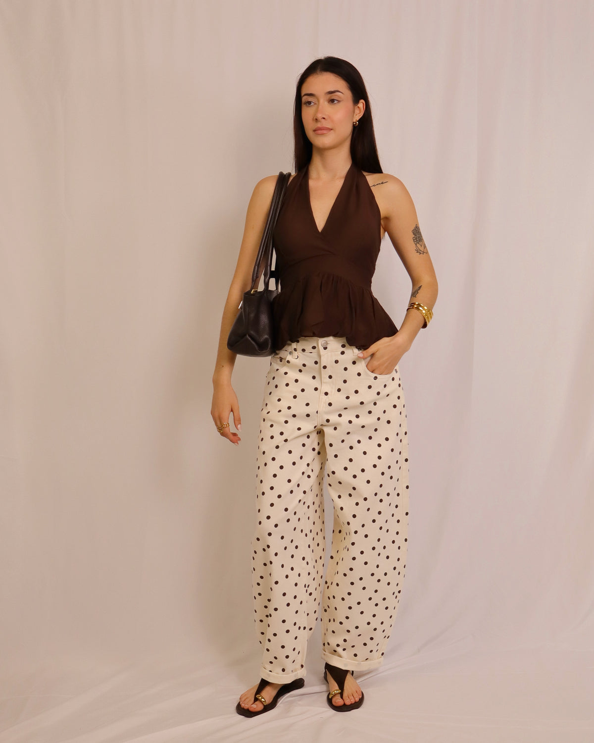 Calça balloon creme com bolinhas pretas, modelo solto e cintura elástica