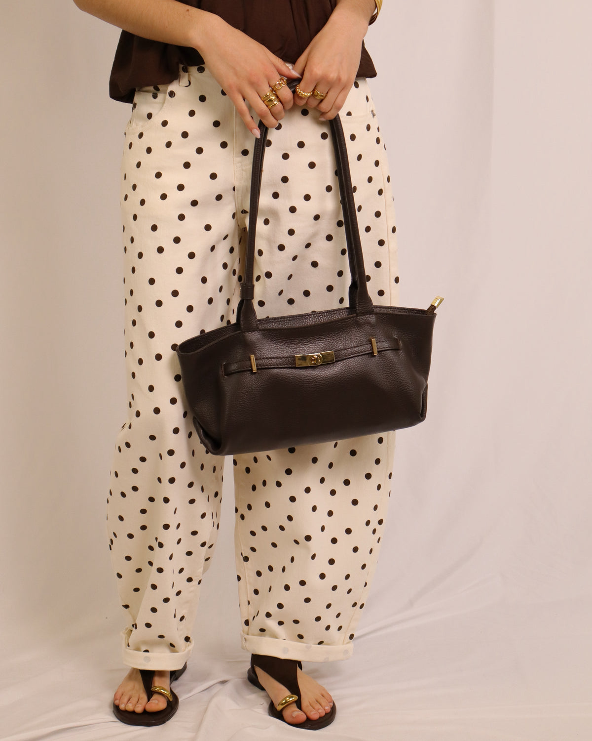 Calça balloon creme com bolinhas pretas, fecho frontal e pernas largas