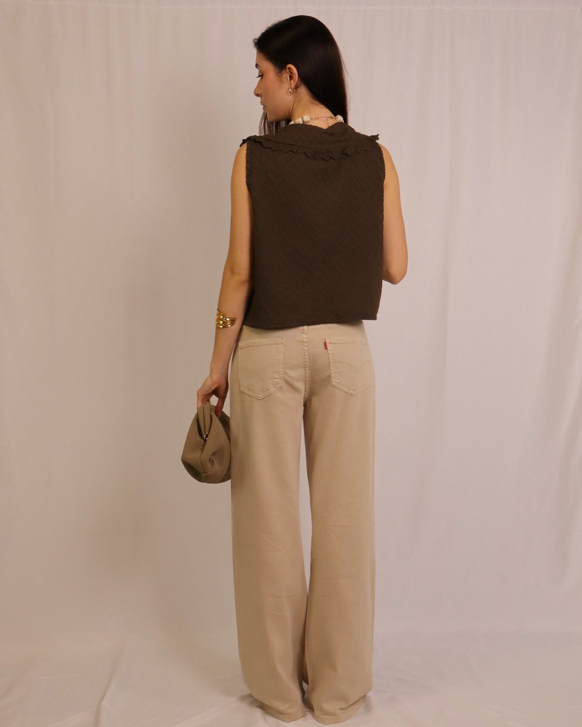 Calça wide leg bege de tecido, com bolsos traseiros e costuras na parte de trás