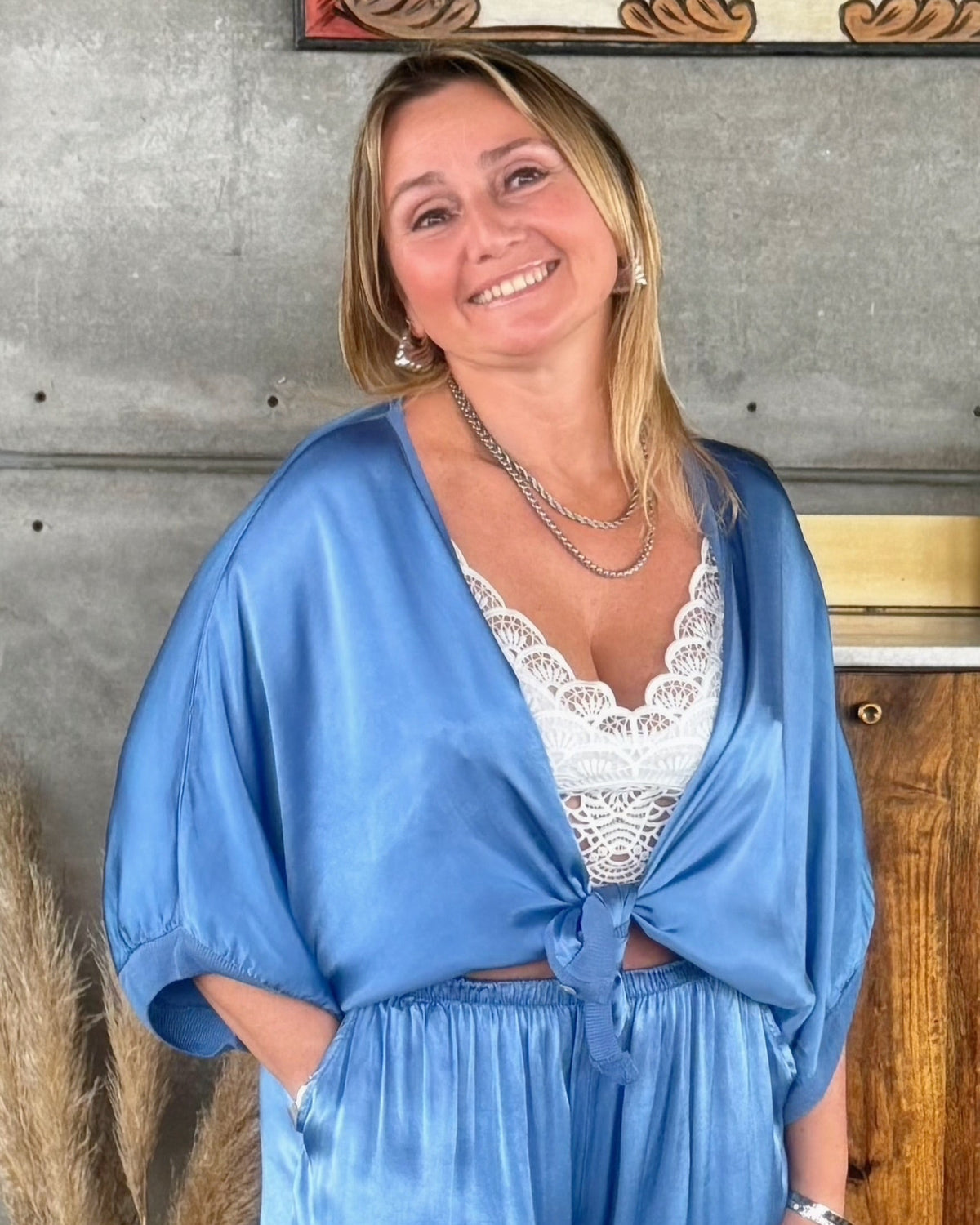 Casaco em tecido acetinado azul-céu, com botões frontais e cintura franzida