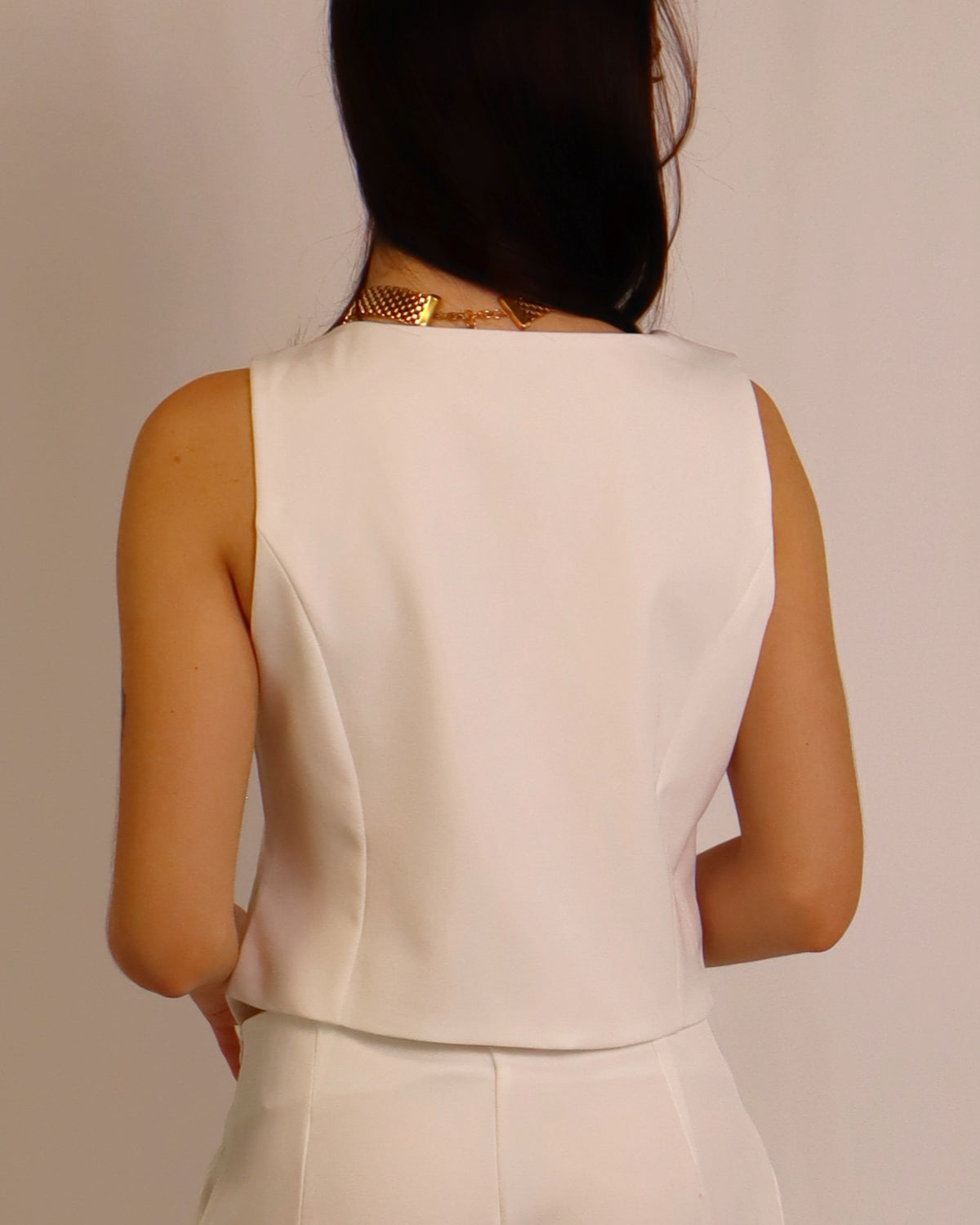 Conjunto de fato branco com top/colete sem mangas e calças largas, vista traseira