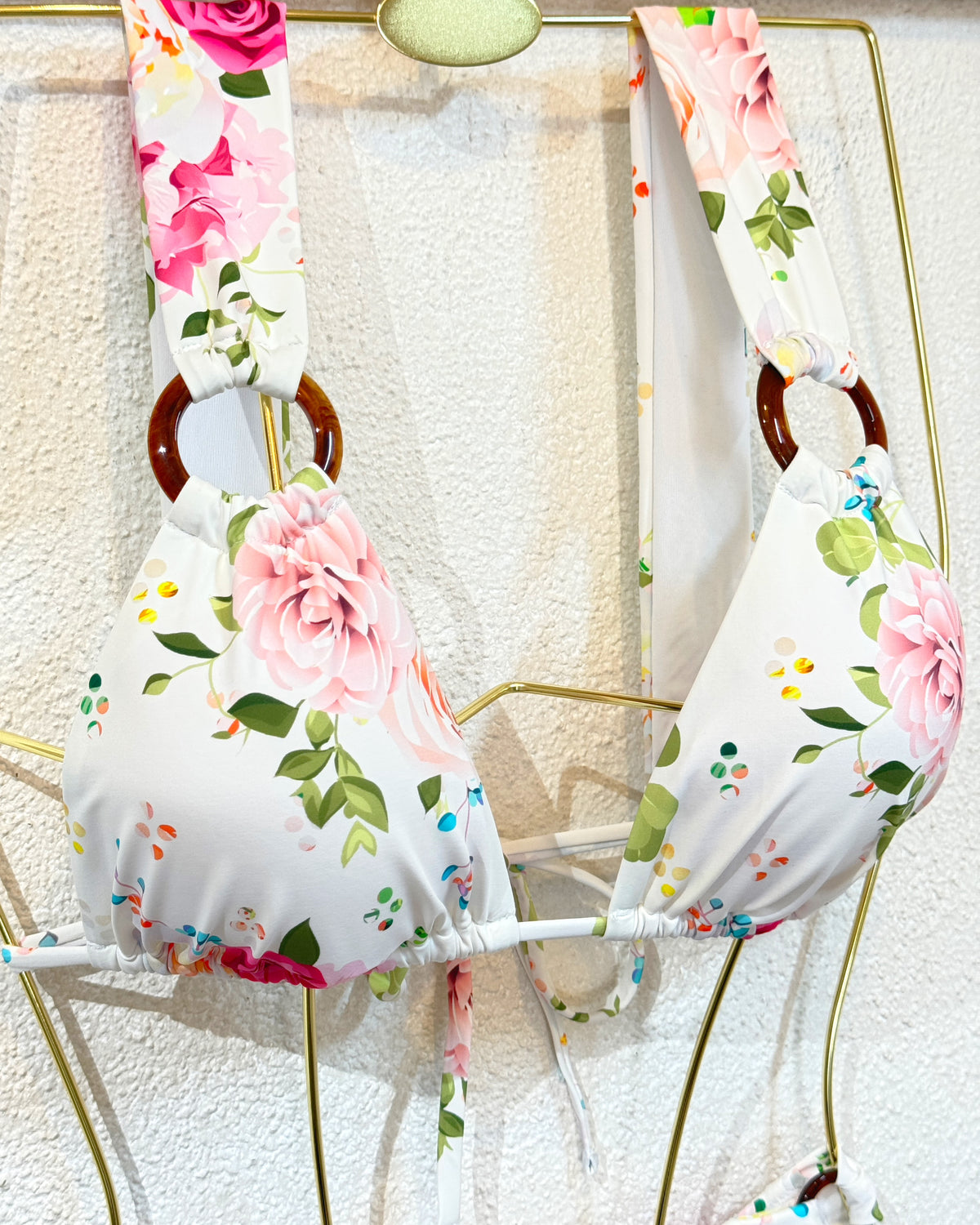 Parte de cima de biquíni branca com flores cor-de-rosa, alças e folhos nas copas