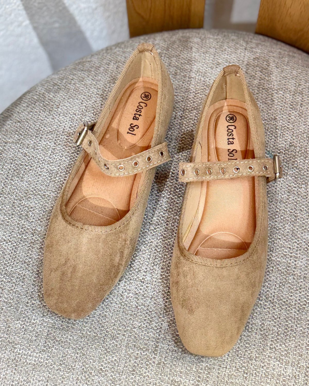 Sapatos em camurça bege com tira ajustável e fivela metálica, ilhós decorativos