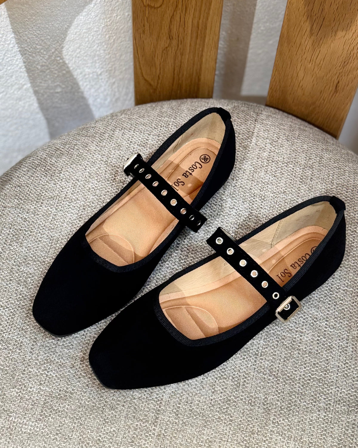 Sapatos pretos de camurça, com tira regulável e fivela metálica com presilhas