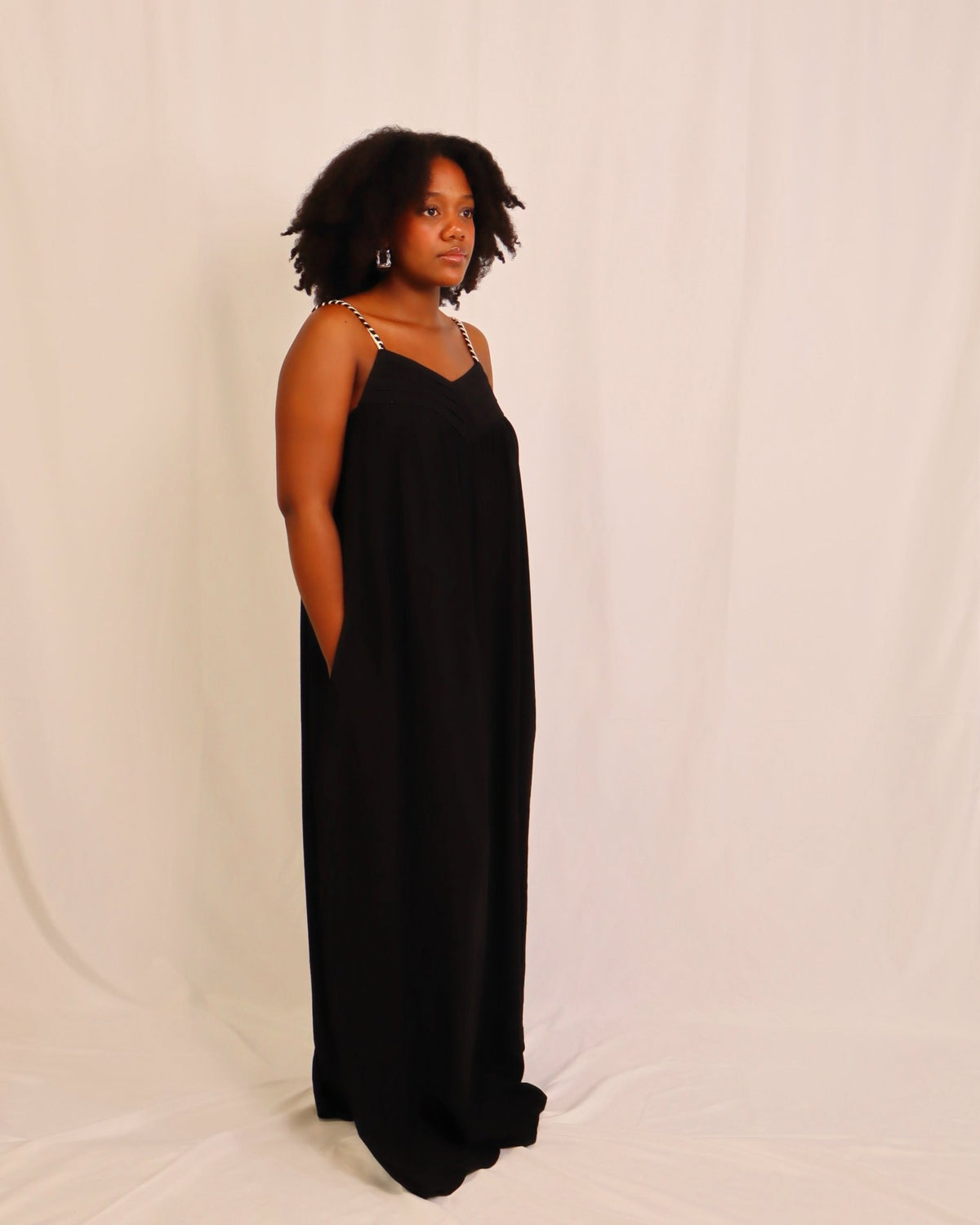 Vestido de alças fluido preto, decote V e saia comprida em tecido leve.